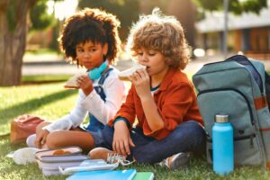 A couple of children enjoying a breakfast leveraging the benefits of nutrition in early childhood.